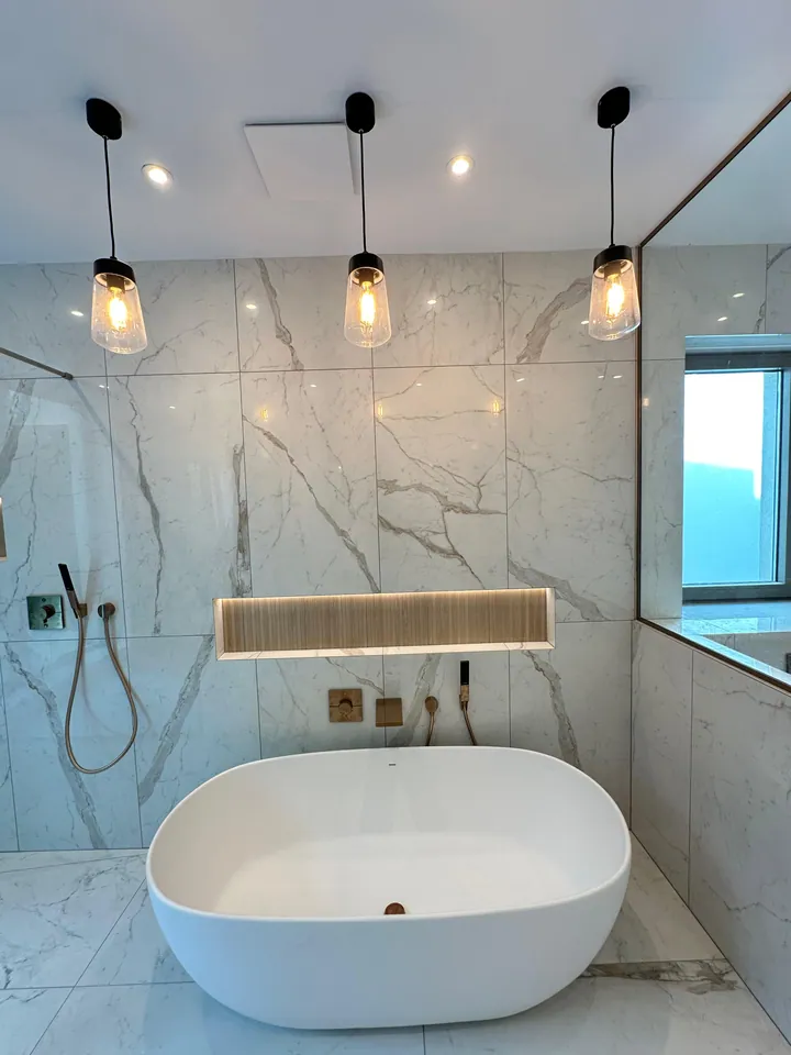 Freestanding bath with marble-effect tiling