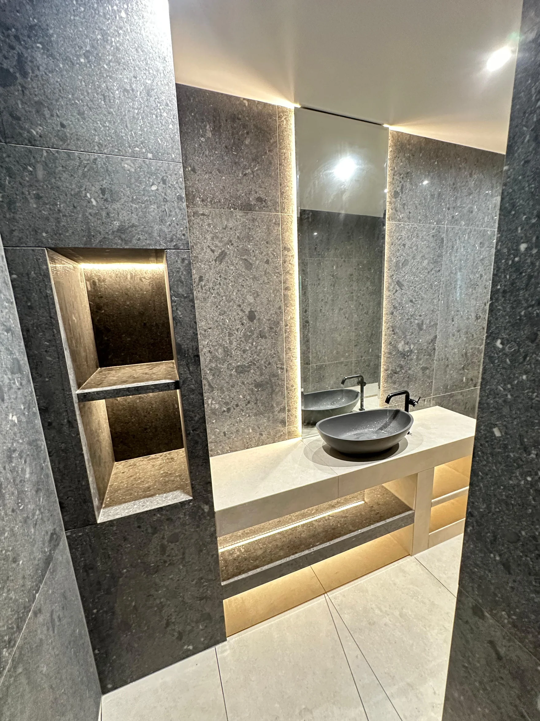 Refined bathroom finish with illuminated niche and vessel basin