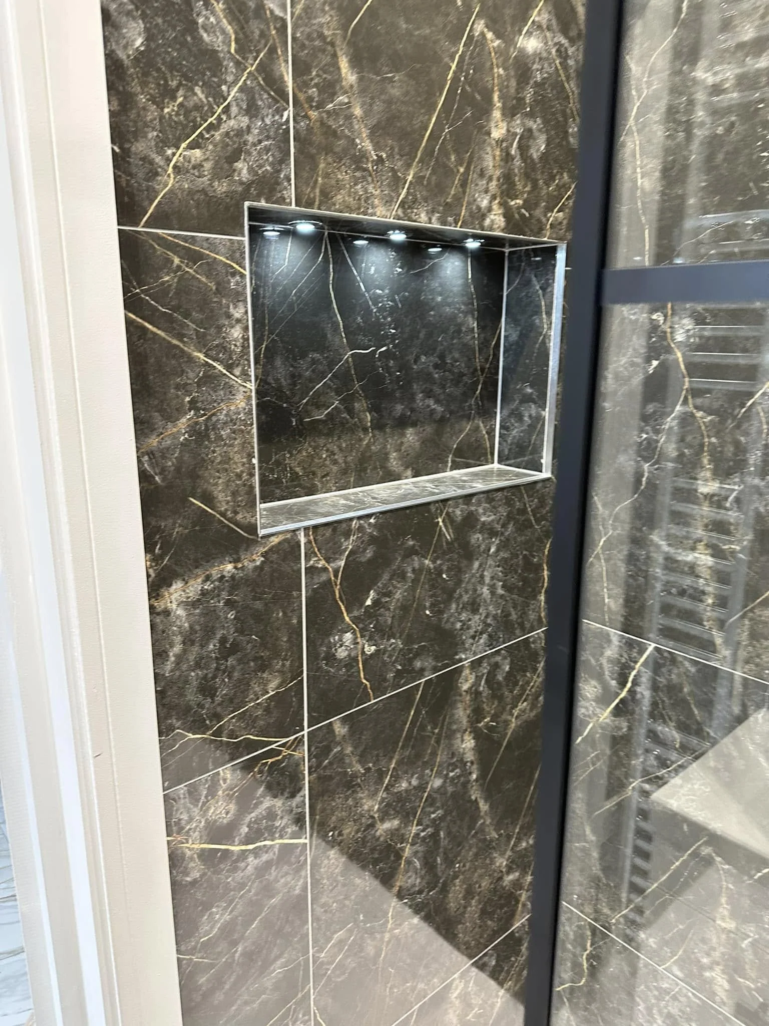 Shower area with dark stone-look tiles